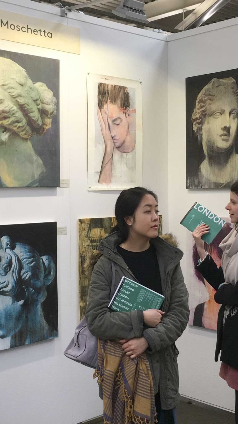 Visitor with the fair catalogue among Ancient Beauty works, The Other Art Fair London 2019