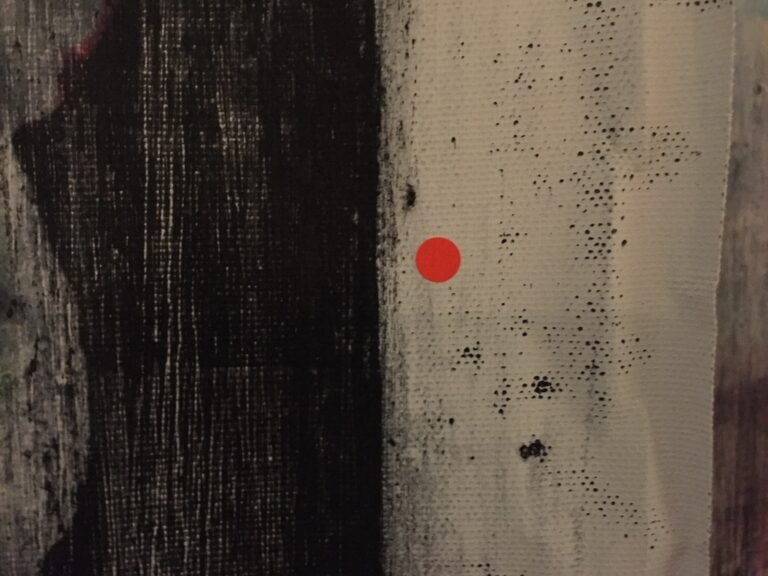 Red sold dot on the edge of a dark canvas, Artrooms London 2018