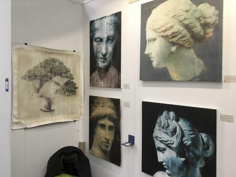 Booth wall with Ancient Beauty paintings of classical heads and a tree on paper, The Other Art Fair 2019