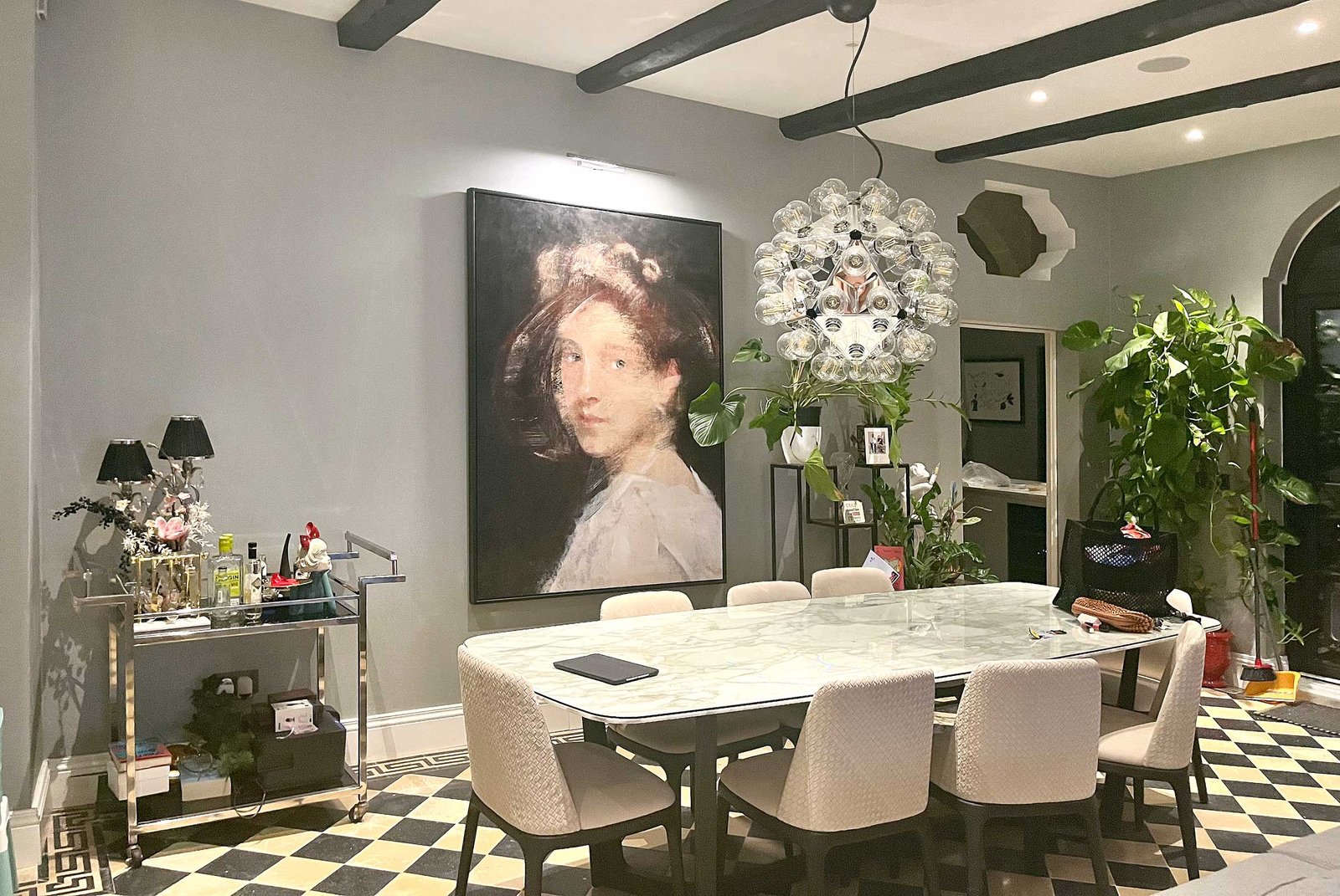Large female portrait painting by Dario Moschetta displayed in a modern dining room interior