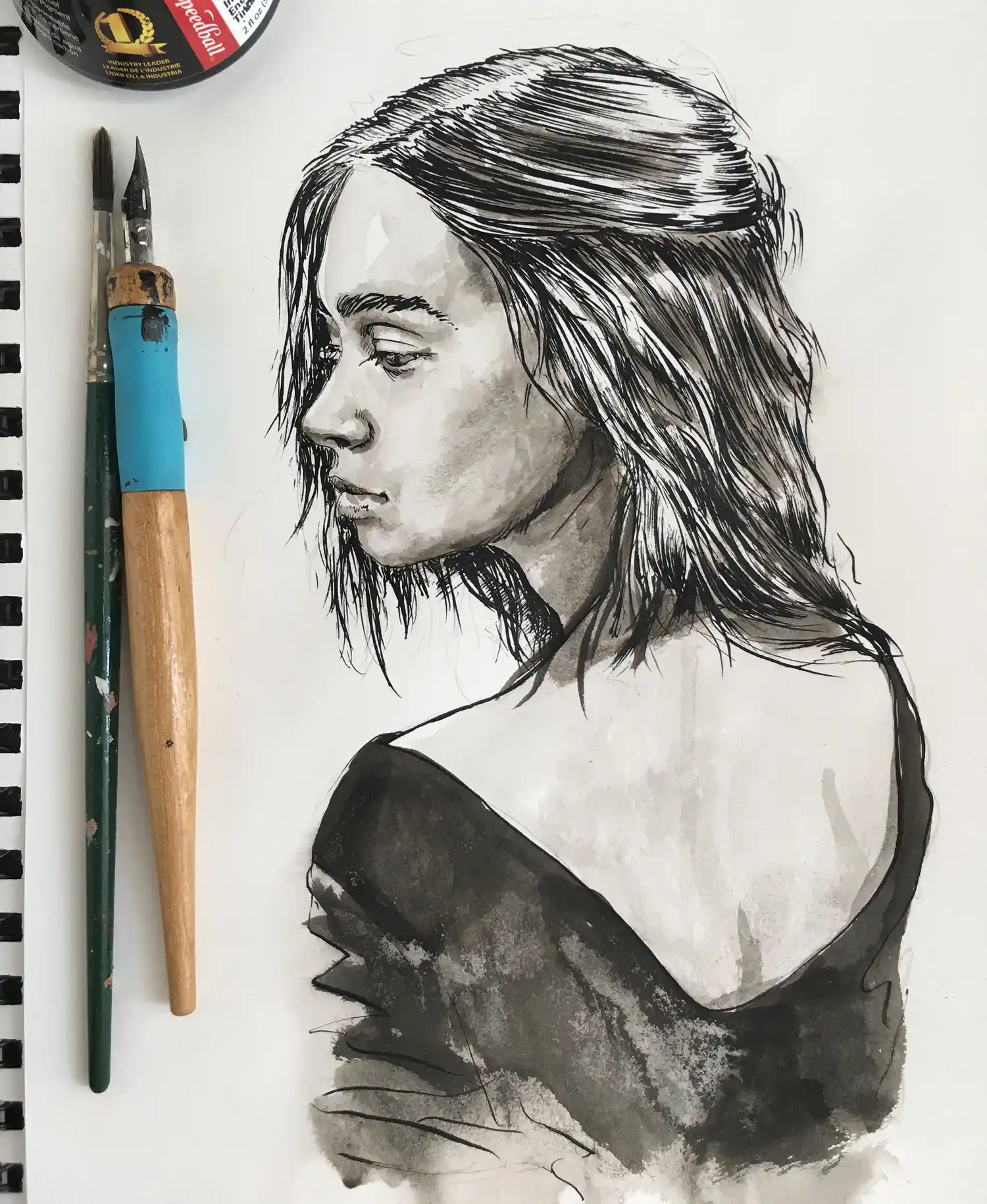 Ink and watercolor portrait drawing on artist’s desk with brushes — handmade artwork by Dario Moschetta