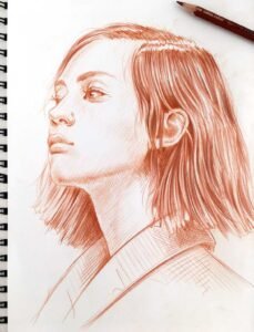 “Terracotta Light” red pastel portrait drawing by Dario Moschetta – female figure in sketchbook view