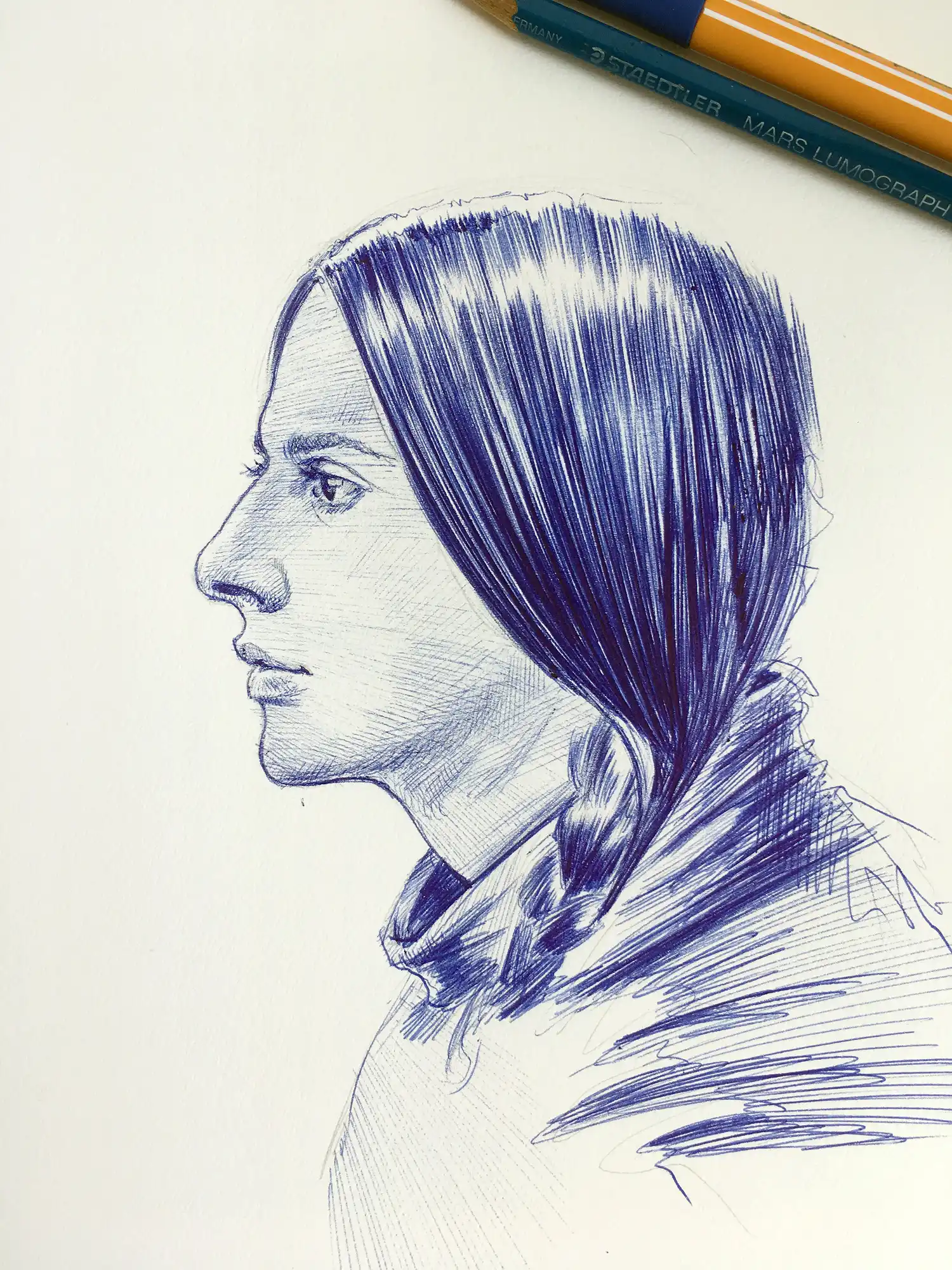 Contemporary female portrait drawn with blue ballpoint pen on paper, profile view