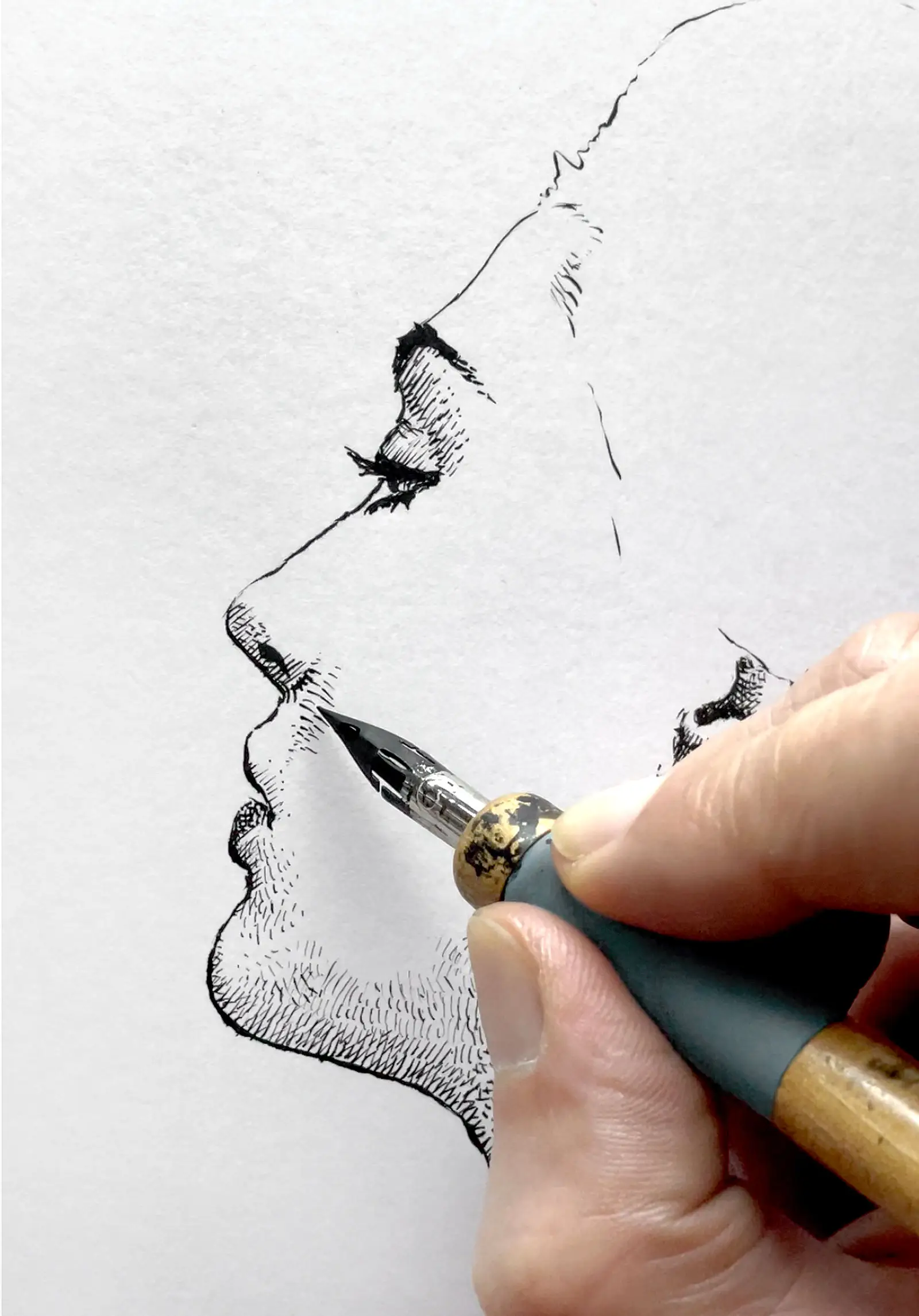 Close-up of female ink drawing showing hand and pen working on profile portrait details