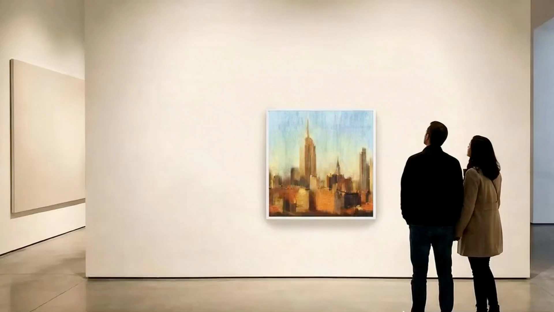 Two people viewing a colourful contemporary painting on a white gallery wall