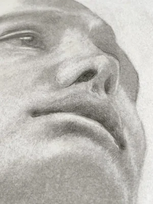 Detail of the nose and lips in a realistic graphite and white pastel portrait drawing on paper