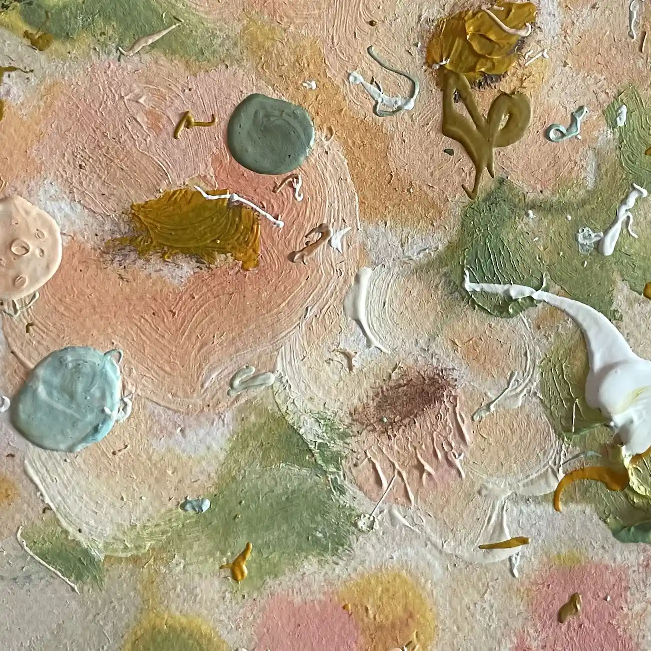 Close up of peach and pink brushstrokes with green leaves and raised drops of grey green, pale blue and white paint